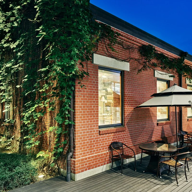 Ivy-covered brick exterior of Coffee Libre and Owolui Jong at Times Square