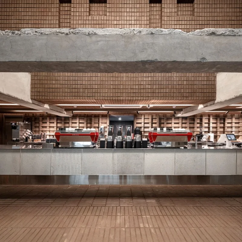 Long coffee counter, exposed concrete and brickwork inside INC Coffee Gasan