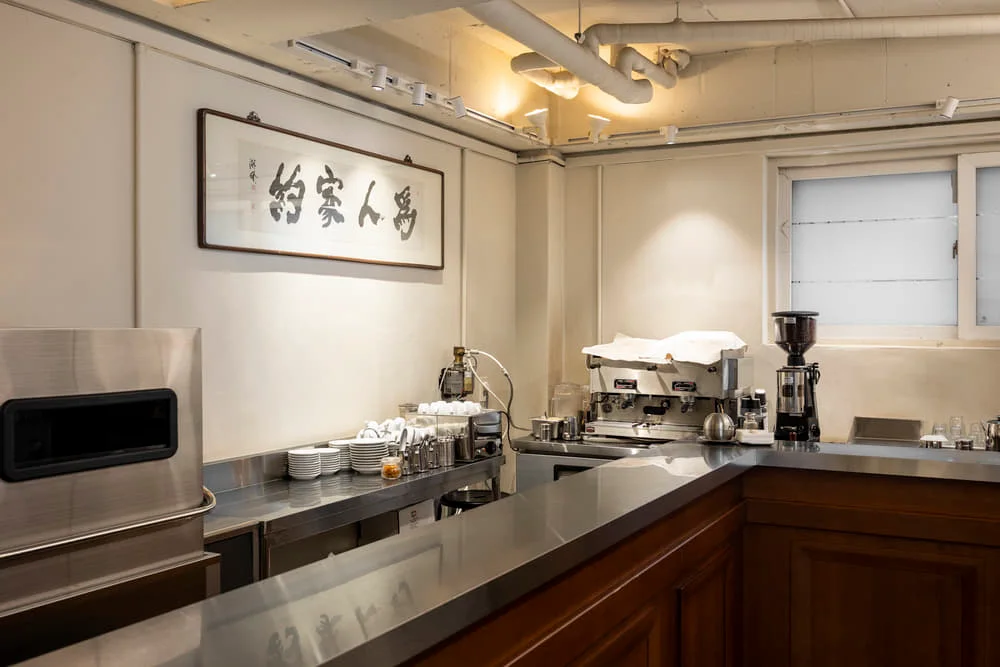 L-shaped espresso counter with timber panels and metal worktop at Leesar’s Yaksu bar.