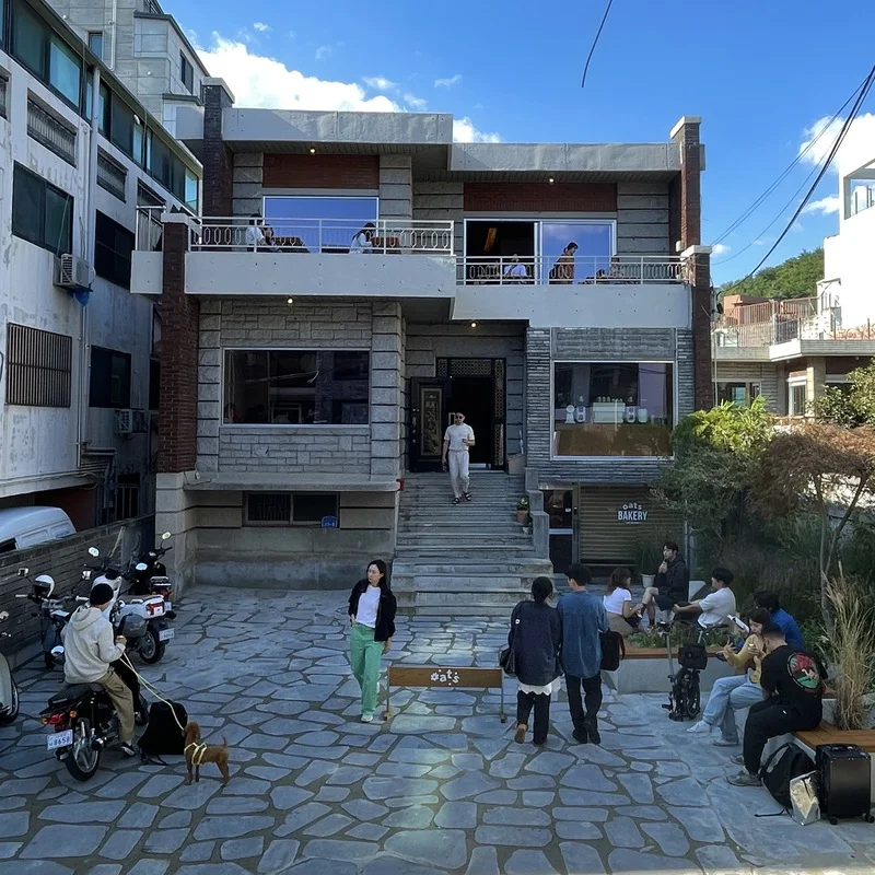 The brick house exterior of Oats Coffee Yeonnam, photographed from its entrance approach.
