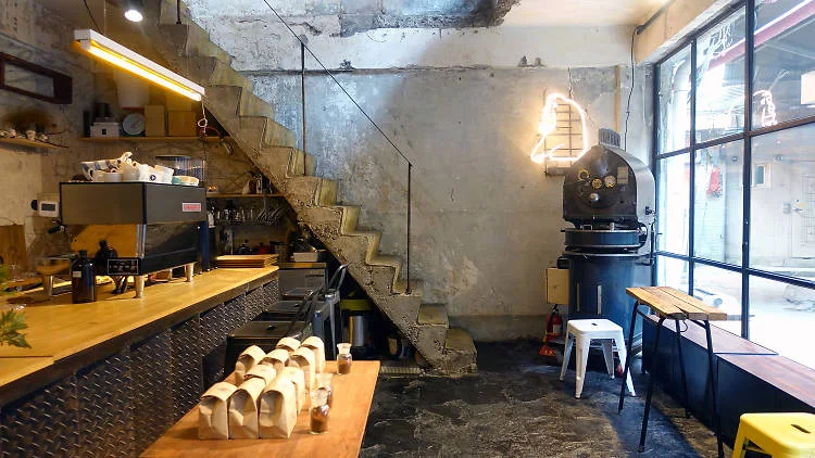 Roasting machine beside the stairs and coffee counter inside Orang Orang at Sinheung Market.