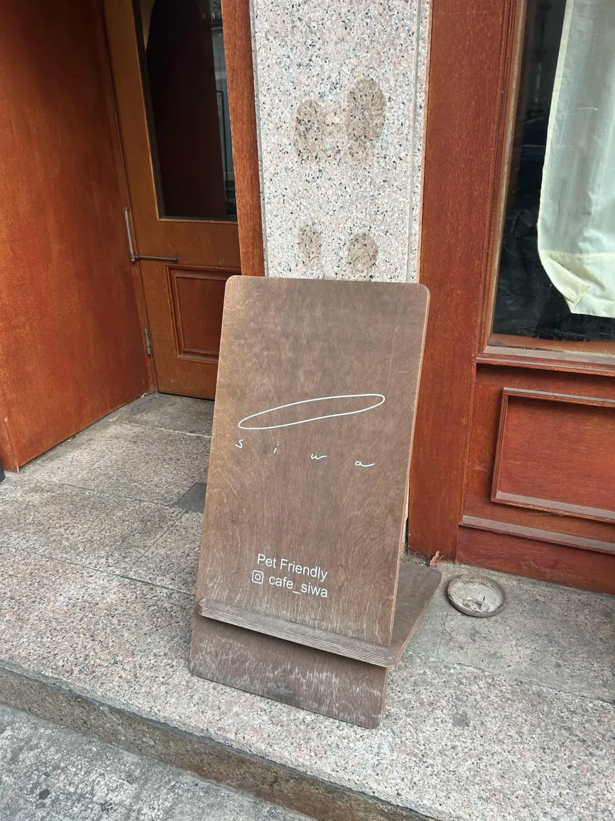 Cafe Siwa sign in front of the Dongseon café’s wooden entrance doors.