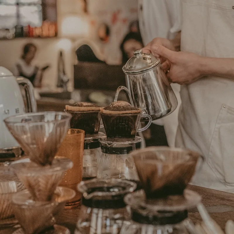 A barista prepares several pour-over coffees at the YM Coffee House counter in Yeonsinnae.